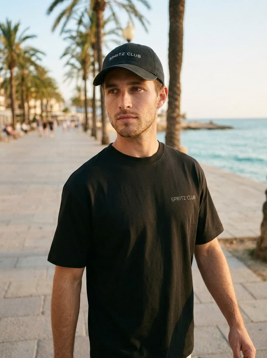 The cap on a man on a sunlit seafront promenade, golden hour